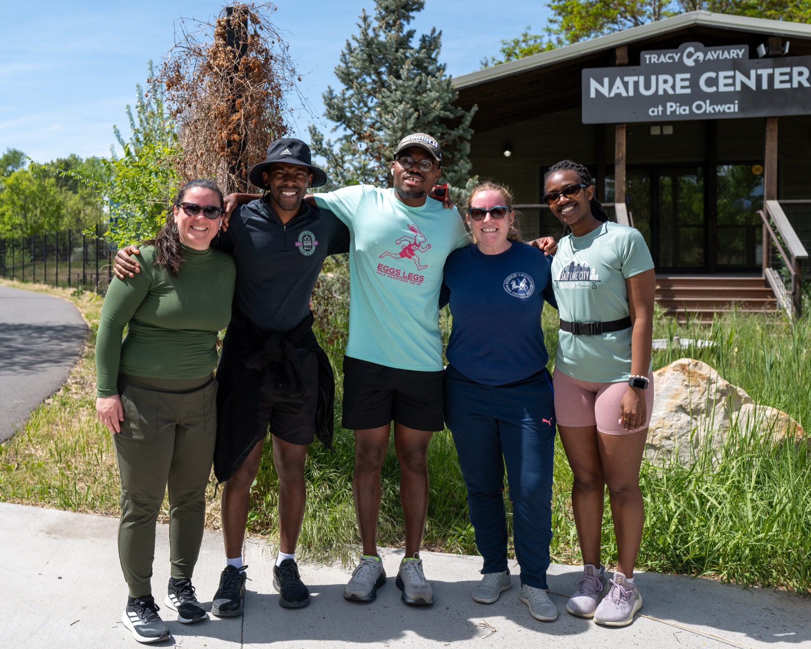 Five community members smiling together outside a nature center.