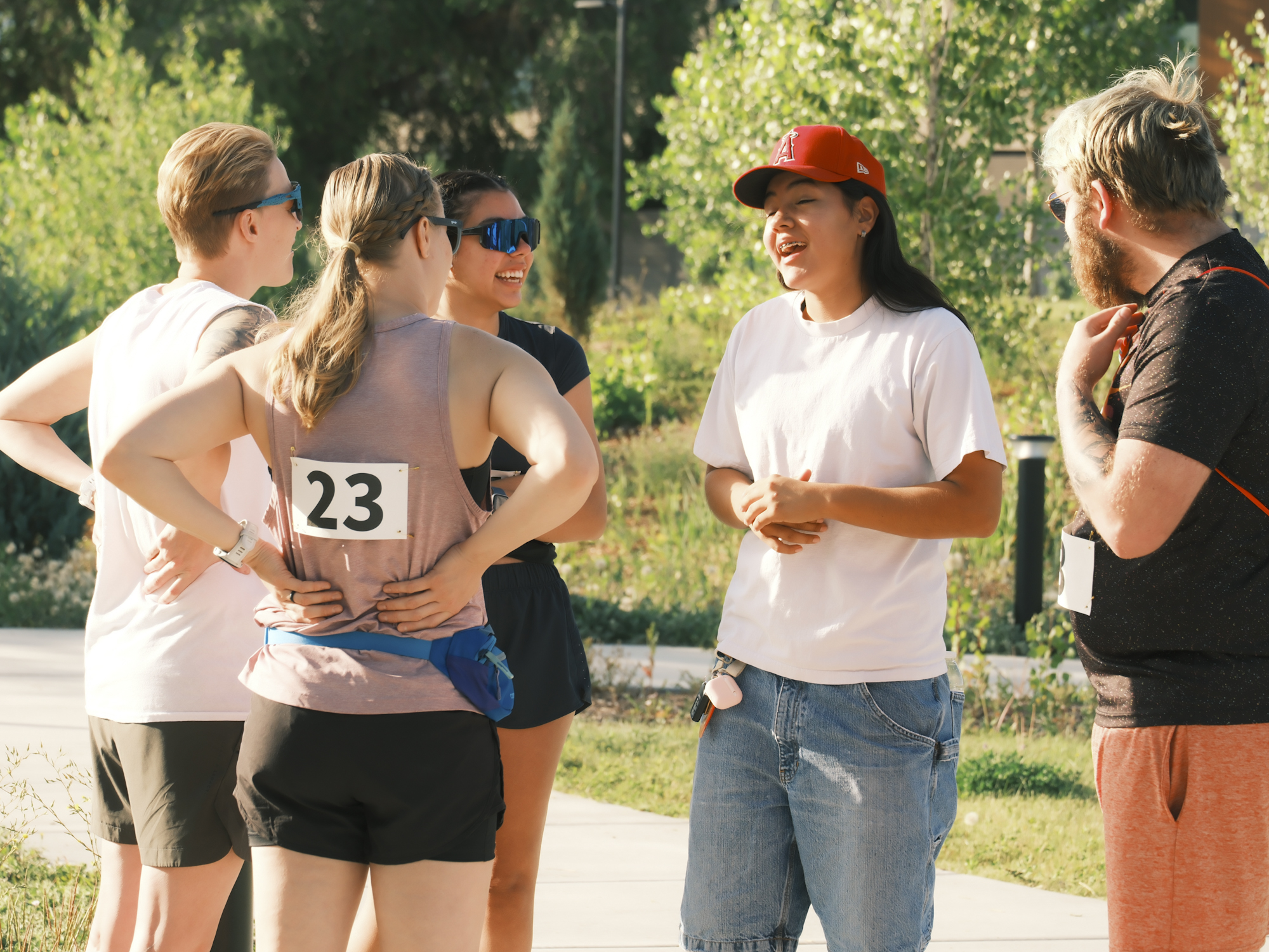 Community members talking and laughing together at an outdoor event.