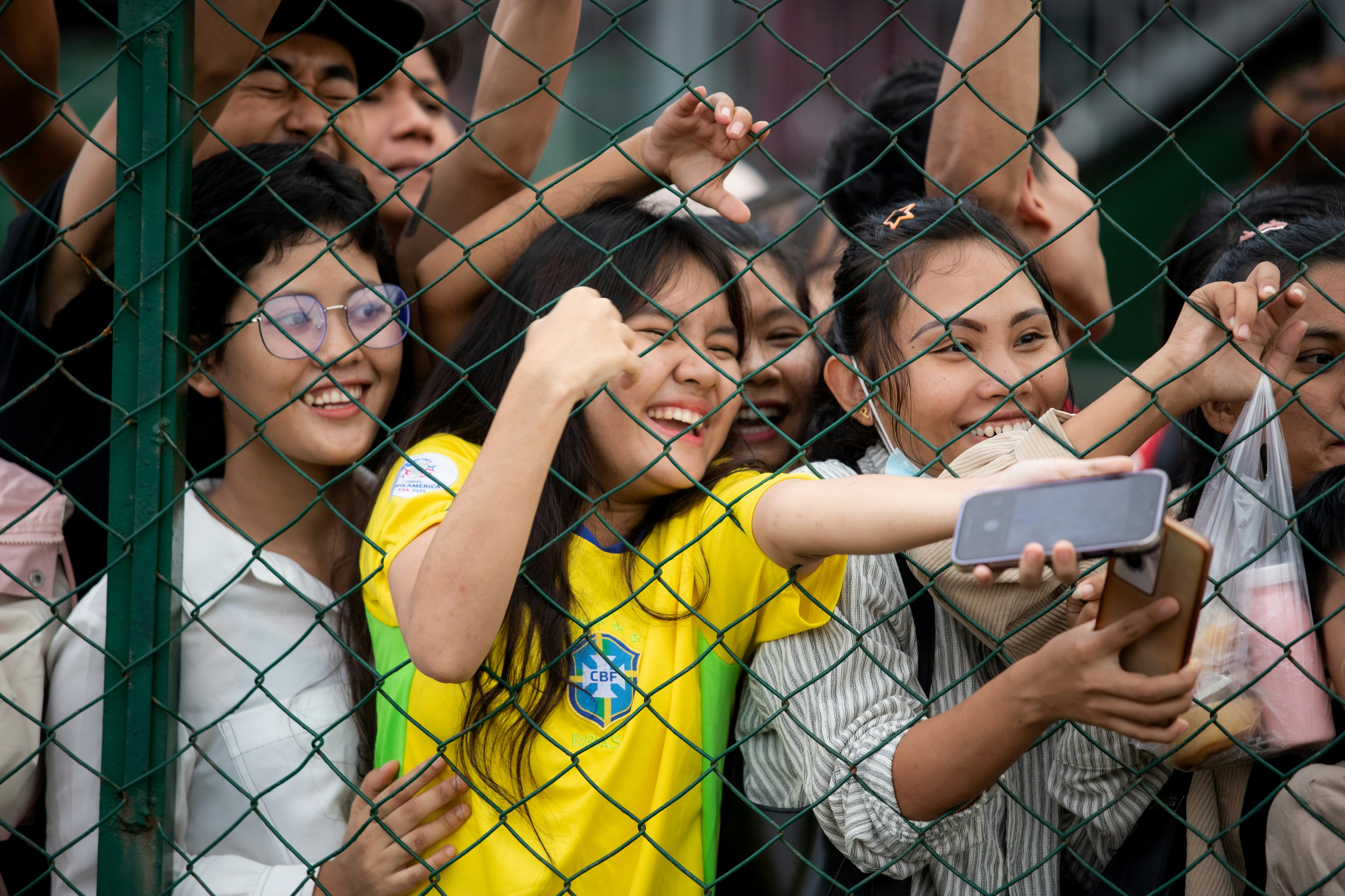 A group of smiling spectators enjoying a sporting event together.