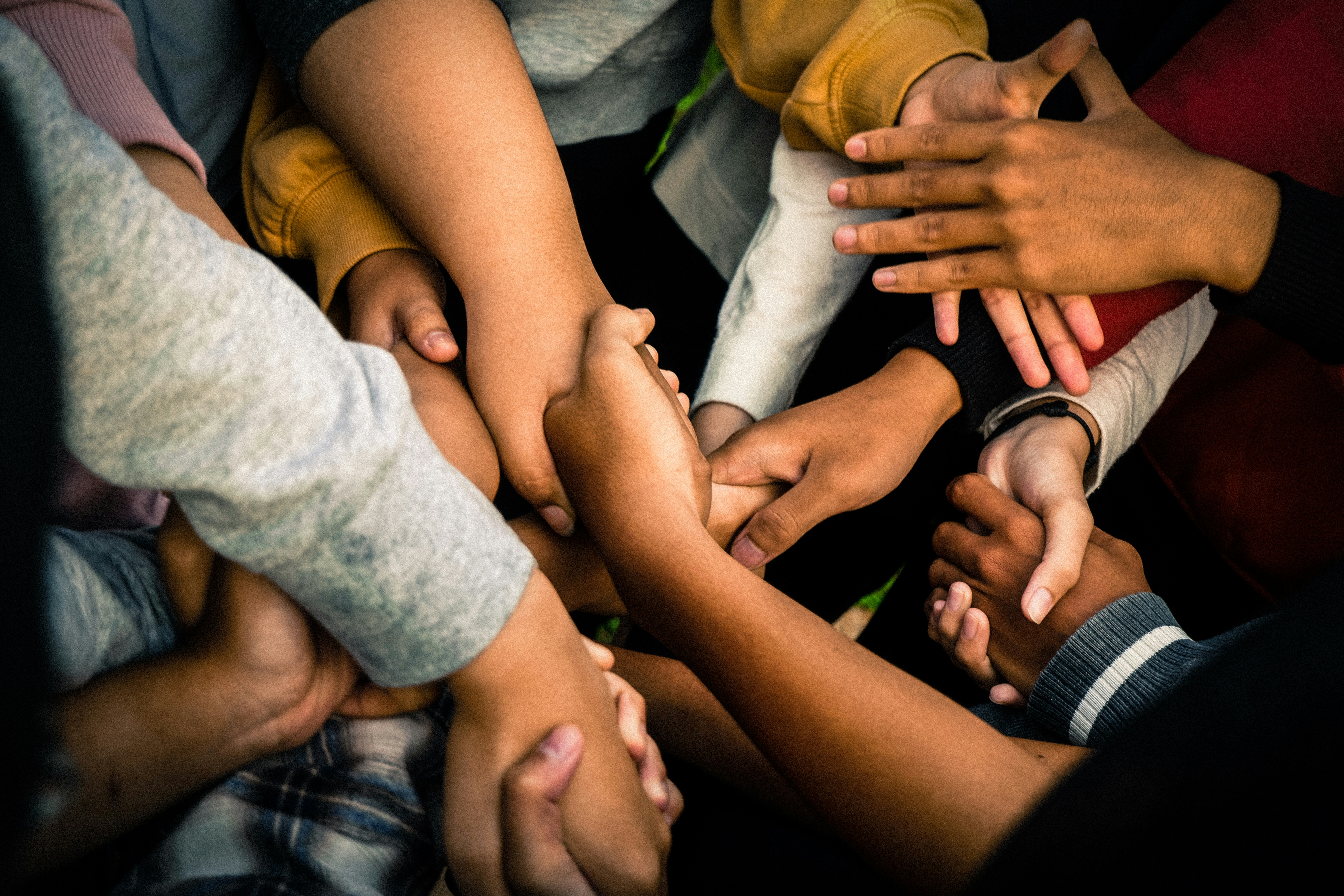 A group of people joining hands in a circle.