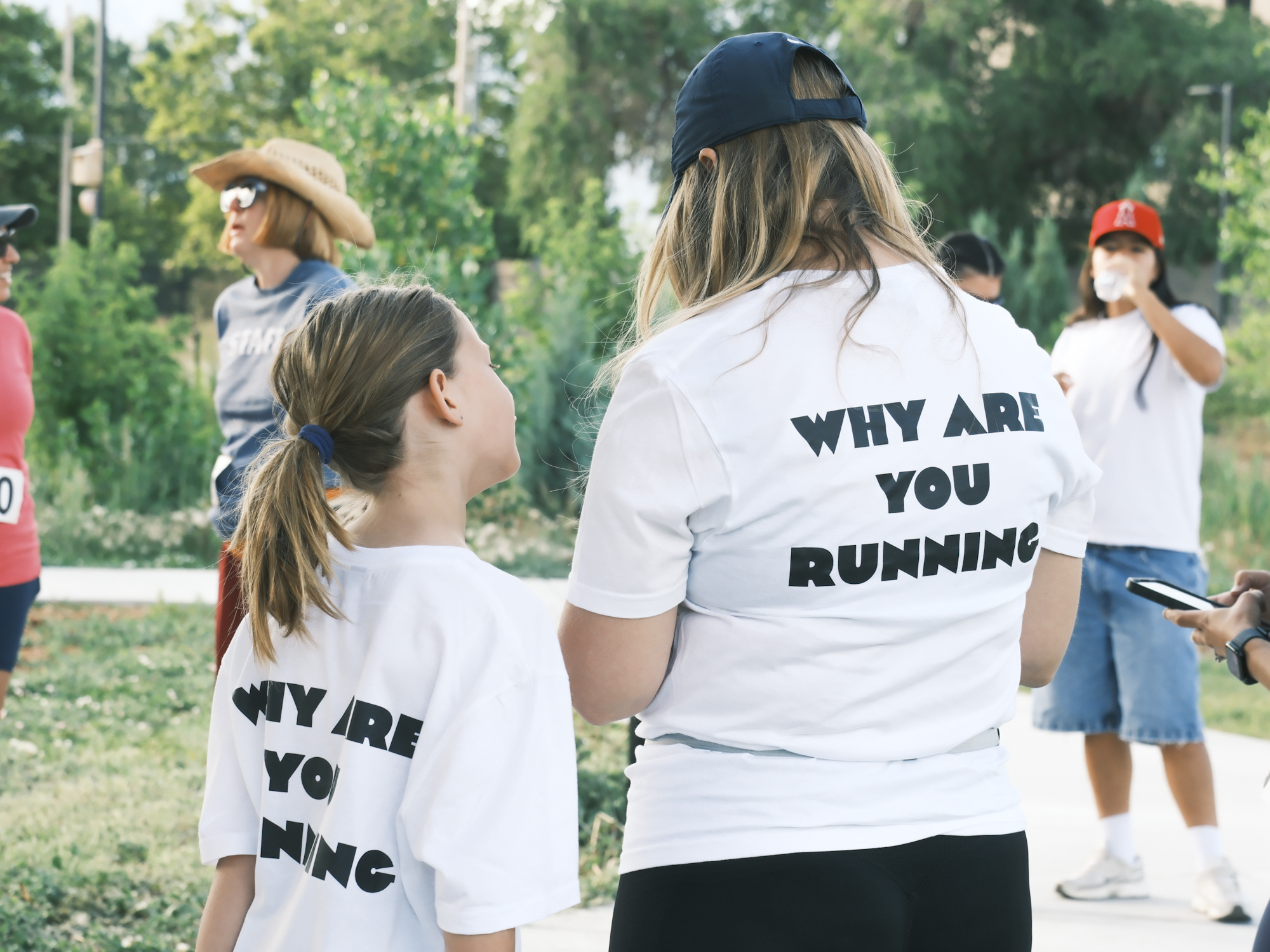 Community members wearing Why Are You Running shirts at the gathering.