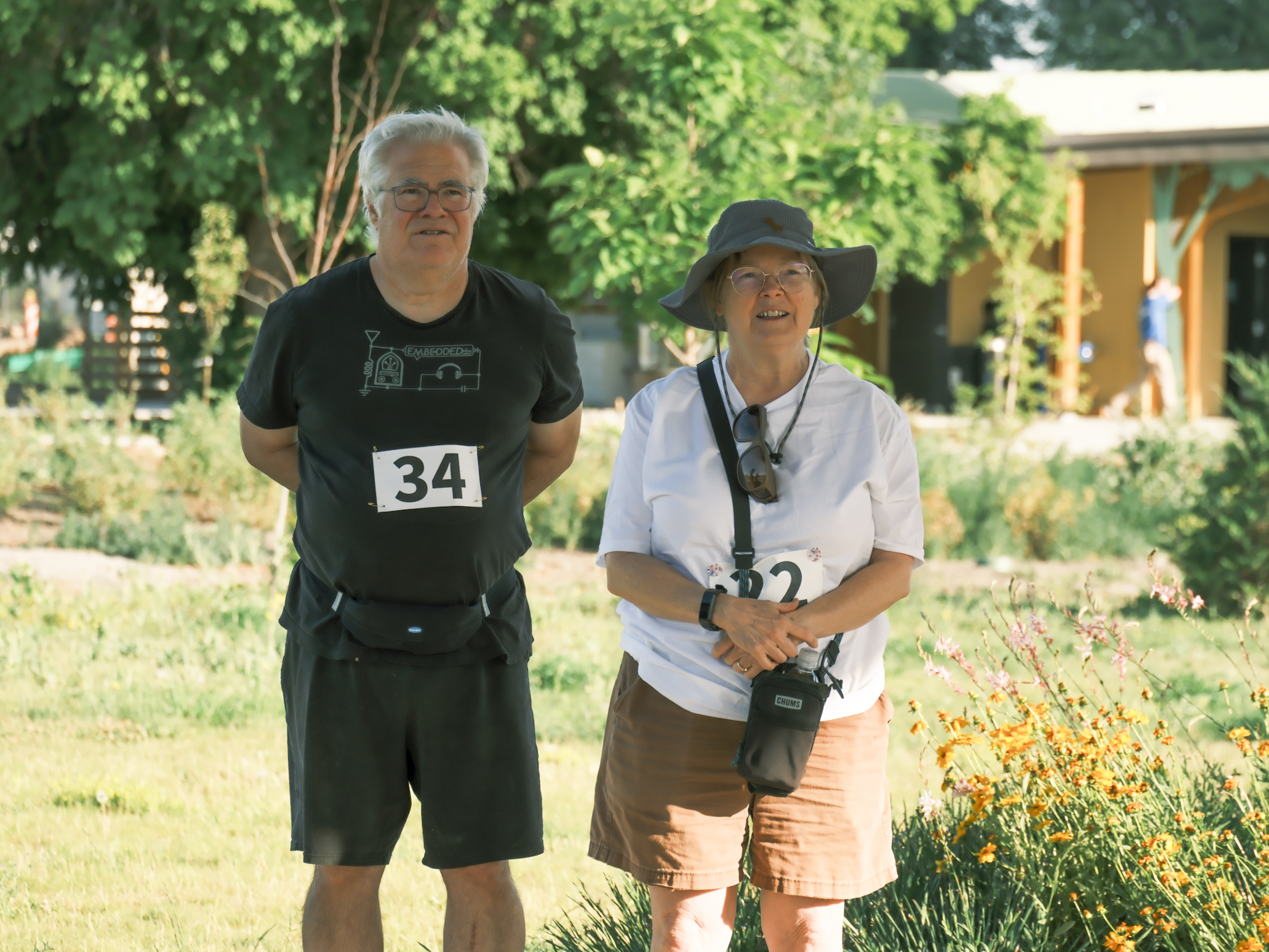 Two participants wearing race bibs at the community celebration.